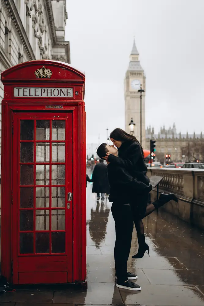 Couple kissing by a red phone box with Big Ben in the background