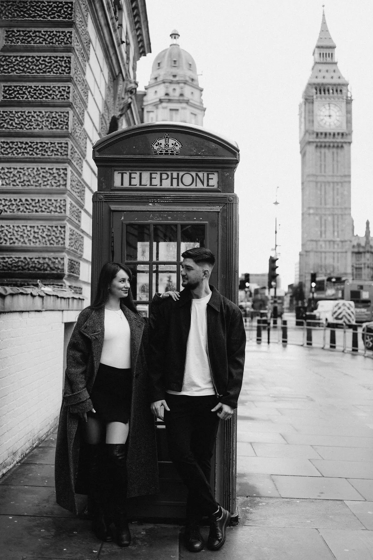 Black and white photo of a couple by a London phone box and Big Ben