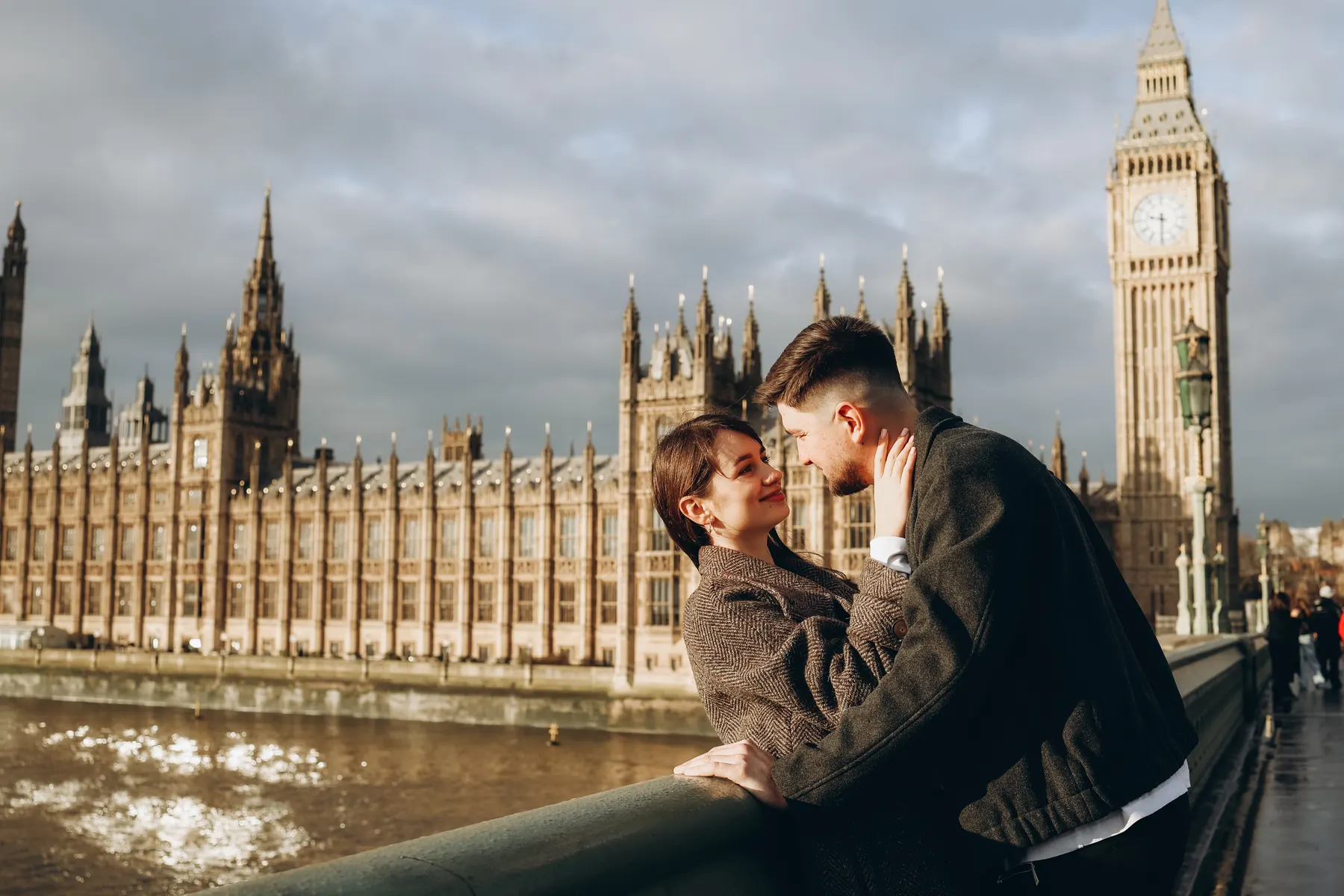 Couple on Westminster Bridge in winter sun with the Houses of Parliament and Big Ben
