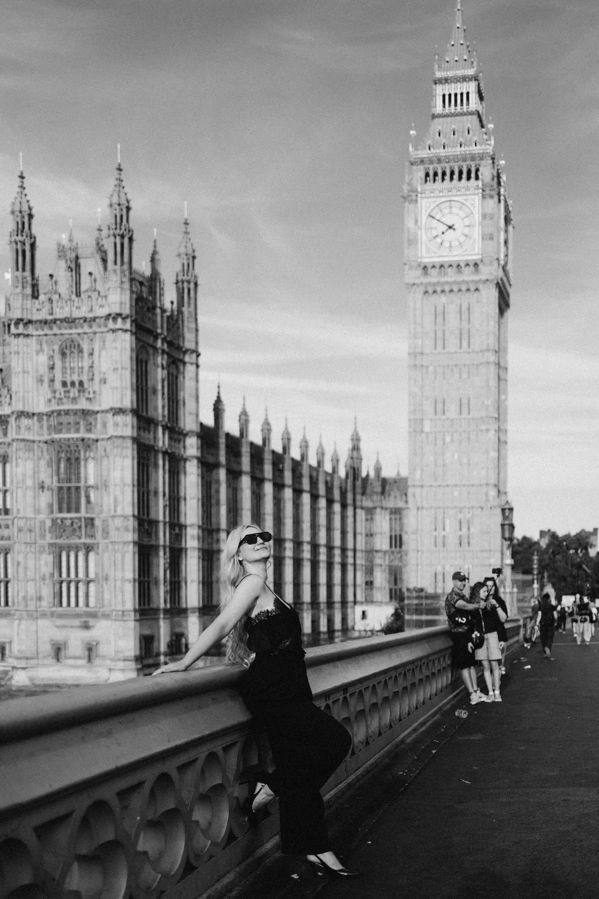 Black and white portrait of a woman in sunglasses on Westminster Bridge by Big Ben