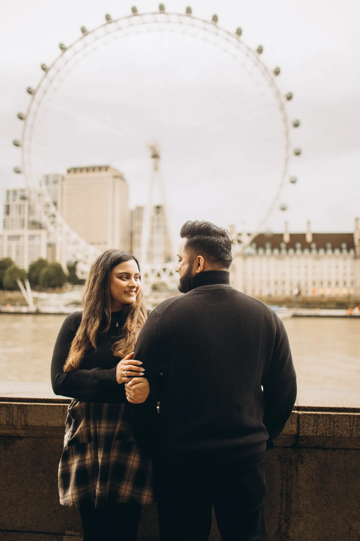 Couple by the river wall with the London Eye across the Thames, during a Big Ben photoshoot