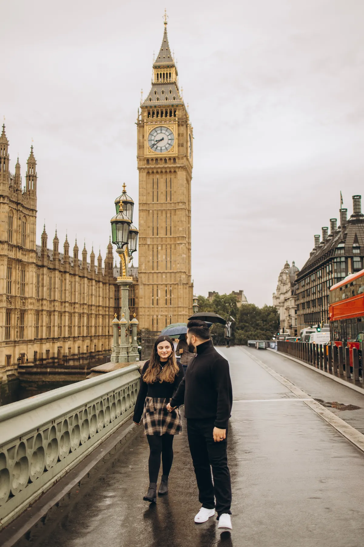 Couple walking hand in hand on Westminster Bridge next to Big Ben